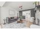 Stylish living room with a gray sofa, ceiling fan, and a brick fireplace, creating a comfortable and inviting space at 5622 Tangerine S Ave, Gulfport, FL 33707