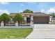 Home exterior features a well-maintained lawn, decorative fence, and a two-car garage at 5812 Blossom Ave, Tampa, FL 33614