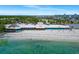 Aerial view of beachfront restaurant with outdoor seating, surrounded by palm trees and ocean views at 611 Destiny Dr, Ruskin, FL 33570