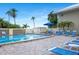 Community pool area features clear water, lounge chairs, and tropical landscaping for relaxation and enjoyment at 611 Destiny Dr, Ruskin, FL 33570
