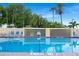 Sparkling community pool with clear water, surrounded by lounge chairs, palm trees and lush landscaping at 611 Destiny Dr, Ruskin, FL 33570