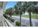 Condo balcony view featuring palm trees, manicured landscaping, parking, and a scenic view of the bay at 611 Destiny Dr, Ruskin, FL 33570
