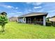 A great shot of the backyard featuring a screened in patio and a luscious green lawn at 6127 Colmar Pl, Apollo Beach, FL 33572