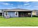 Exterior view of backyard featuring a screened patio, lush lawn, and well-maintained landscaping at 6127 Colmar Pl, Apollo Beach, FL 33572