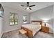 This is a cozy bedroom featuring a ceiling fan, a wooden bed frame, and plenty of natural light from the windows at 6127 Colmar Pl, Apollo Beach, FL 33572