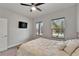 This is a well-lit bedroom featuring a wall-mounted TV, two windows, and a light-colored bed at 6127 Colmar Pl, Apollo Beach, FL 33572