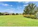 Beautiful view of common green space with healthy, green grass, mature trees, and vibrant landscaping at 6127 Colmar Pl, Apollo Beach, FL 33572