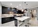 Modern kitchen boasts sleek cabinetry, a quartz countertop island with seating, and stainless steel appliances at 6127 Colmar Pl, Apollo Beach, FL 33572