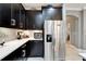 Kitchen with dark wood cabinets, stainless steel refrigerator, and white countertops at 6127 Colmar Pl, Apollo Beach, FL 33572
