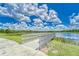 Scenic lake view with a wooden walkway, lush greenery, and serene atmosphere at 6127 Colmar Pl, Apollo Beach, FL 33572
