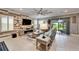 Open concept living room with media center, ceiling fan, tile floors and sliding doors at 6127 Colmar Pl, Apollo Beach, FL 33572