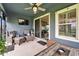 Inviting covered patio with comfortable seating, ceiling fan, and sliding glass doors for indoor-outdoor living at 6127 Colmar Pl, Apollo Beach, FL 33572