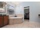 Bright bathroom features a soaking tub, large window, and closet at 6416 Grenada Island Ave, Apollo Beach, FL 33572