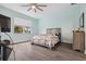 Serene bedroom with light-blue walls, wood-look flooring, and a comfortable bed with coastal-themed bedding at 6416 Grenada Island Ave, Apollo Beach, FL 33572