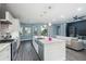 Open kitchen with island, stainless appliances, white cabinetry, and seamless flow into the living area at 6416 Grenada Island Ave, Apollo Beach, FL 33572
