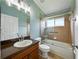 Bathroom with vanity, a glass-enclosed shower and tub with tiled walls and window at 6957 Boulder Run Loop, Wesley Chapel, FL 33545