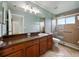 Bathroom features a vanity with cabinets, large mirror, and tiled glass shower at 6957 Boulder Run Loop, Wesley Chapel, FL 33545