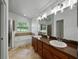 Bathroom features dual sinks, a soaking tub under a large window, and a separate glass door shower at 6957 Boulder Run Loop, Wesley Chapel, FL 33545