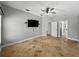 Large bedroom with ceiling fan, tv, and view to the hallway at 6957 Boulder Run Loop, Wesley Chapel, FL 33545