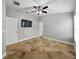Bedroom featuring tile flooring, ceiling fan with light, and large television at 6957 Boulder Run Loop, Wesley Chapel, FL 33545