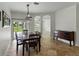 Dining room with dark wood table and chairs, leading to a sliding glass door to the backyard at 6957 Boulder Run Loop, Wesley Chapel, FL 33545