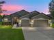 Charming single-story home with a three car garage and well-manicured lawn and stone facade at 6957 Boulder Run Loop, Wesley Chapel, FL 33545