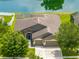 A bird's eye view of the home showcases its roof, landscaping, and proximity to a serene pond at 6957 Boulder Run Loop, Wesley Chapel, FL 33545