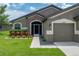 Inviting front entrance of a well-maintained home with a manicured lawn and stone accents at 6957 Boulder Run Loop, Wesley Chapel, FL 33545