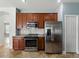 A kitchen showcasing stainless steel appliances, solid countertops, and wood cabinets at 6957 Boulder Run Loop, Wesley Chapel, FL 33545