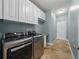Laundry room with front load washer and dryer, tile floor, and lots of storage at 6957 Boulder Run Loop, Wesley Chapel, FL 33545