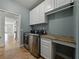 Laundry room with granite countertop, tile floor, washer, and dryer at 6957 Boulder Run Loop, Wesley Chapel, FL 33545