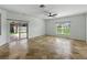 Living room features a sliding glass door, tile flooring, and large window at 6957 Boulder Run Loop, Wesley Chapel, FL 33545