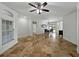 Open-concept living area featuring travertine flooring, arched entryways, and plenty of natural light at 6957 Boulder Run Loop, Wesley Chapel, FL 33545