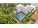 Aerial view of the screened-in pool and the back of the home at 7613 Bramblewood Dr, Port Richey, FL 34668