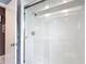 Bathroom showcasing a glass-enclosed shower and white tile at 7613 Bramblewood Dr, Port Richey, FL 34668