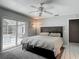 Bedroom featuring a ceiling fan, tiled floor, and sliding glass doors to the pool area at 7613 Bramblewood Dr, Port Richey, FL 34668