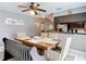 Dining area with wooden table, unique seating, decorative ceiling fan and artwork on the walls at 7613 Bramblewood Dr, Port Richey, FL 34668