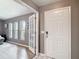 Light-filled entryway with white paneled doors, gray walls, light wood floors, and a glimpse into the living area at 7613 Bramblewood Dr, Port Richey, FL 34668