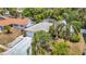 An exterior view shows stone accents, a two-car garage, mature trees, and lush landscaping at 7613 Bramblewood Dr, Port Richey, FL 34668