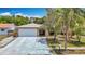 Charming single-story home featuring stone facade, two-car garage, and mature landscaping at 7613 Bramblewood Dr, Port Richey, FL 34668