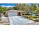 Charming garage with stone accents and a paved driveway leading up to it at 7613 Bramblewood Dr, Port Richey, FL 34668