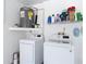 Efficient laundry room with modern washer and dryer and ample shelving at 7613 Bramblewood Dr, Port Richey, FL 34668