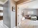 Open living room with light gray walls, wood flooring, neutral furniture, and open doorway to other living spaces at 7613 Bramblewood Dr, Port Richey, FL 34668
