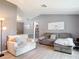 Cozy living room with vaulted ceilings, light gray walls, wood flooring, and comfortable neutral-toned furniture at 7613 Bramblewood Dr, Port Richey, FL 34668