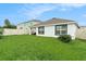 Home exterior and backyard with a well-maintained lawn, fence, patio and lush landscaping at 7639 Broad Pointe Dr, Zephyrhills, FL 33540