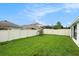 Spacious backyard with a well-maintained lawn, a white fence and landscaping for outdoor enjoyment at 7639 Broad Pointe Dr, Zephyrhills, FL 33540