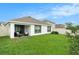 Well-kept backyard with a lush green lawn, covered patio, and white perimeter fencing at 7639 Broad Pointe Dr, Zephyrhills, FL 33540