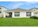 Wide view of the home's backyard featuring a well-manicured lawn, patio and white perimeter fence at 7639 Broad Pointe Dr, Zephyrhills, FL 33540