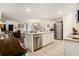 Open kitchen with stainless steel appliances, white cabinetry and island, flowing into a spacious living area at 7639 Broad Pointe Dr, Zephyrhills, FL 33540