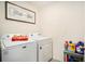 Functional laundry area equipped with a washer, dryer, and convenient storage shelves at 7639 Broad Pointe Dr, Zephyrhills, FL 33540